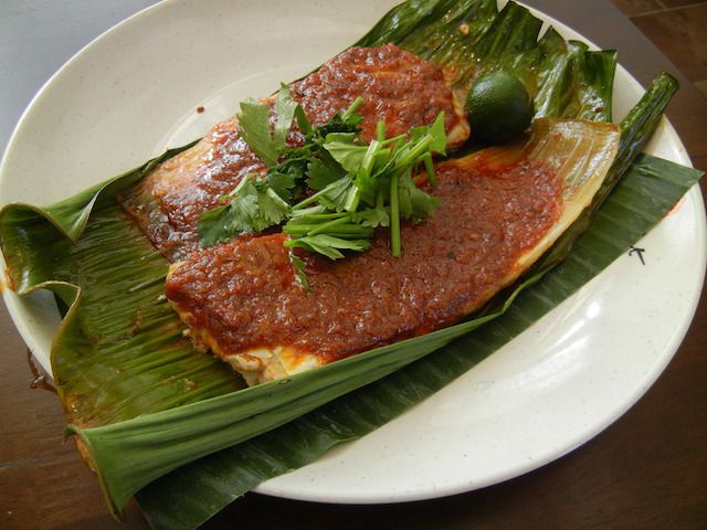 Sambal stingray from Lau Pa Sat. Singaporeans love seafood and spices. Sambal is a chili paste blended with lots of different spices, shallots, and fermented shrimp paste. The stingray is wrapped in banana leaves and grilled until the meat has a smoky barbeque flavor.